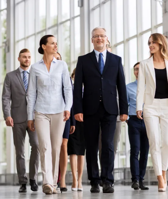Group of business professionals walking confidently in a modern office environment at Moving Heads Recruitment Agency