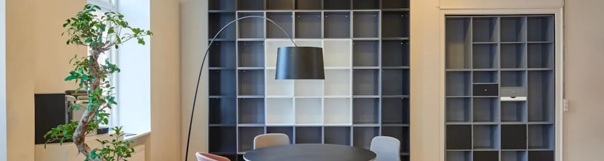 Modern office meeting area with a round table, chairs, and shelving at Moving Heads Recruitment Agency